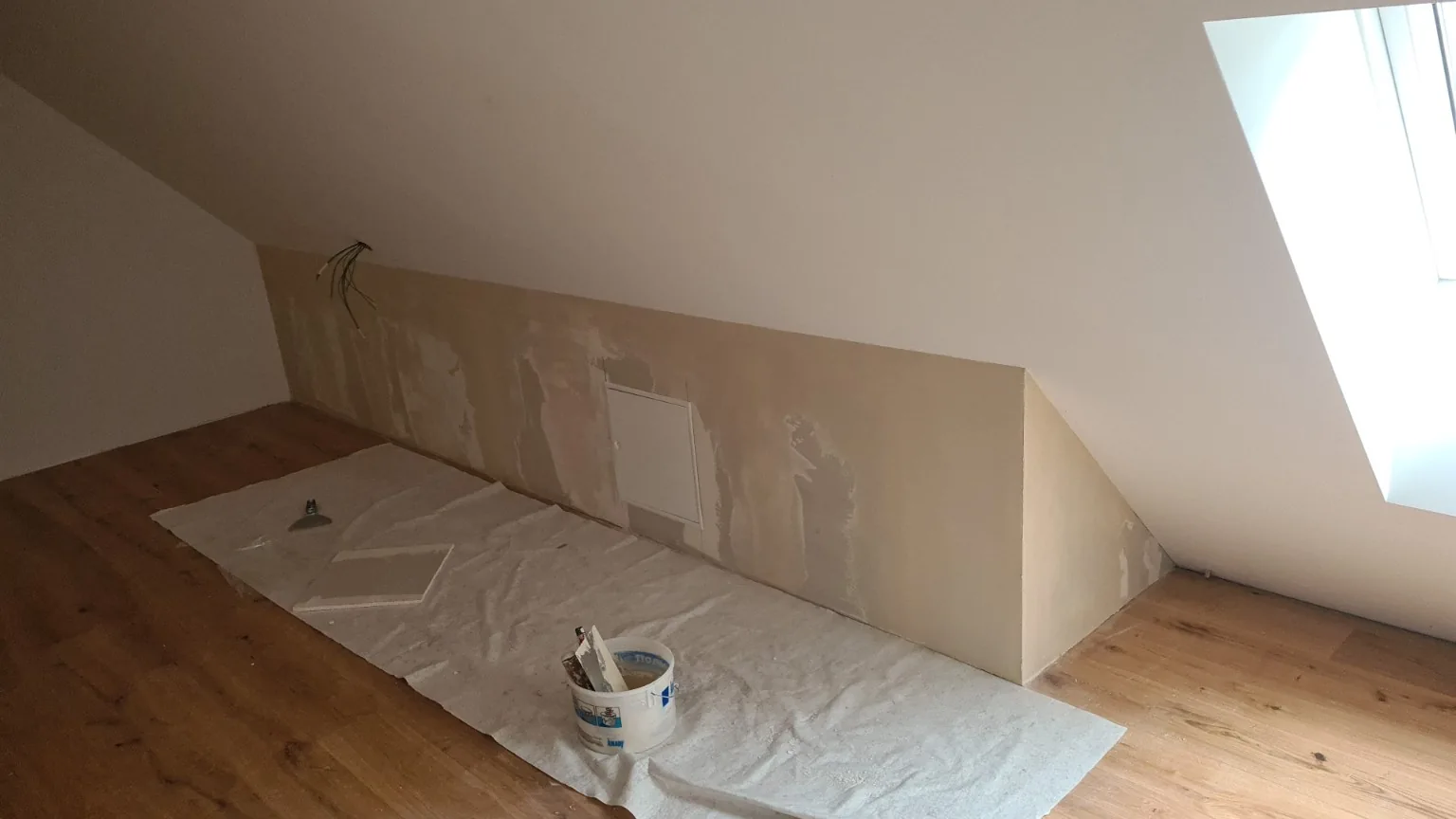 Beplankte und gespachtelte Drempelwand mit Revisionstür unter einer Dachschräge