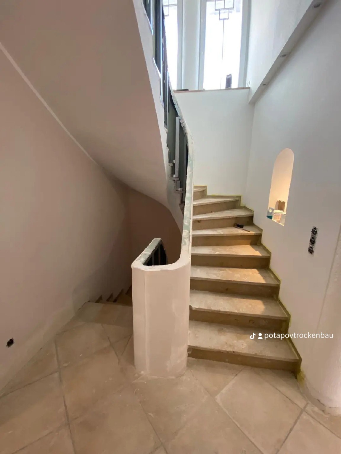 Modernisiertes Treppenhaus mit geschwungener Wandverkleidung